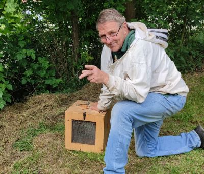 Ein Imker arbeitet an einem Bienenstock.